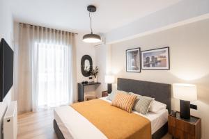 a bedroom with a bed and a large window at The Edge Piraeus Luxury Residences in Piraeus