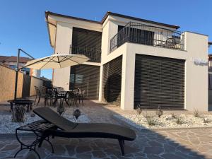 a patio with a table and an umbrella and a building at Vila CampoAmor Pasohlávky in Pasohlávky +10 photos