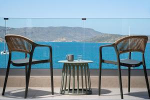 two chairs and a table in front of a window at Blue Horizon Elounda in Elounda