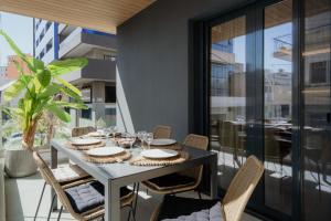 a table and chairs on a balcony with a view of a building at The Edge Piraeus Luxury Residences in Piraeus