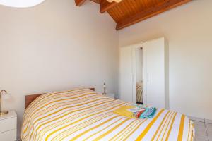 a white bedroom with a striped bed in it at Location Oléron centre La Cotinière in Saint-Pierre-dʼOléron