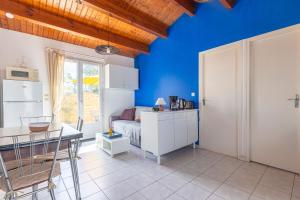 a bedroom with blue walls and a table and a bed at Location Oléron centre La Cotinière in Saint-Pierre-dʼOléron