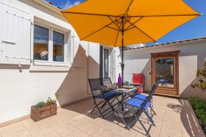 a table and chairs with an umbrella on a patio at Location Oléron centre La Cotinière in Saint-Pierre-dʼOléron +12 photos