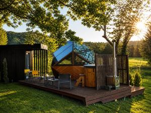 a tiny house with a deck in the yard at LA RÉSERVE DE L'AUBE - Hébergements insolites Luxe et Design in Villenauxe