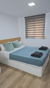 a bedroom with a bed with blue sheets and a window at BEACH Arguineguin FIRST LINE CHG FAMILY HOTEL in Arguineguín
