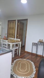 a living room with a table and a rug on the floor at Central Zenteno en Punta Arenas in Punta Arenas