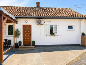 a white house with a brown door and a patio at Apartment Near Zadar Airport & City in Crno