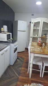 a kitchen with a table and a white refrigerator at Central Zenteno en Punta Arenas in Punta Arenas +7 photos