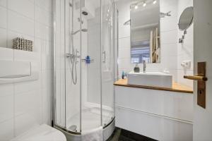 a bathroom with a shower and a toilet and a sink at Stutenhof-EG-Wohnung-3 in Keitum +18 photos