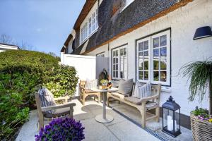 a patio with chairs and a table in front of a house at Stutenhof-EG-Wohnung-3 in Keitum