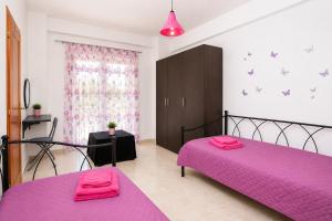 a bedroom with two pink beds and a pink blanket at PROPERSTAY 112 - Maison Calme Polychrono in Polychrono
