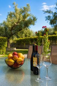 a table with a bowl of fruit and two wine glasses at PROPERSTAY 112 - Maison Calme Polychrono in Polychrono