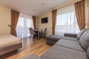 a hotel room with a couch and a table with a dining room at Palangos Vila in Palanga