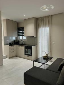 a kitchen and living room with a couch and a table at Kostas apartaments in Korinthos