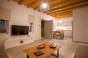 a living room with a table and a tv at Mystic Horizon in Mikonos