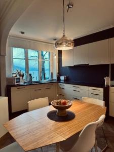 a kitchen with a wooden table with a bowl of fruit on it at Atemberaubende Ferienwohnung direkt am See in Brienz +14 photos