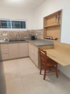 a kitchen with a wooden table and a wooden chair at בית בערבה in Mitzpe Ramon