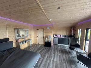 a room with a bed and a kitchen with purple lights at CASSA Sophia in Ballygowan