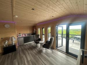 a living room with two chairs and a table and sliding glass doors at CASSA Sophia in Ballygowan +14 photos