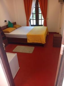 a bedroom with two beds and a red floor at Ella Top Sky in Bandarawela