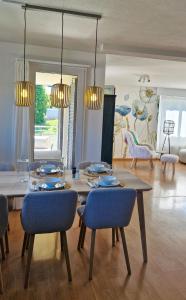 a dining room with a table and blue chairs at Swiss Lakeside Apartments in Spiez