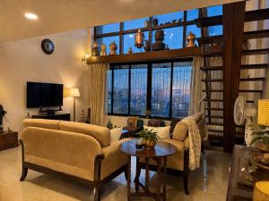 a living room with a couch and a table at Pet Friendly Spacious 3 BHK Penthouse in Mumbai +11 photos