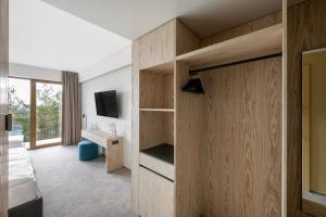 a bedroom with a bed and a desk and a television at Snow Hotel Druskininkai in Druskininkai