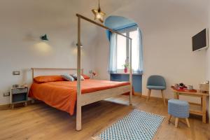 a bedroom with a bed with an orange bedspread at Podere Demetra in Novi Ligure