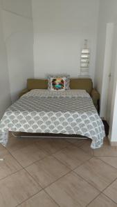 a bedroom with a bed with a white comforter at Le coin des plaisir in Deshaies