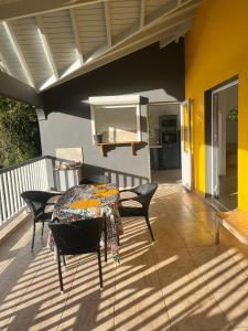 a patio with a table and chairs on a deck at Le coin des plaisir in Deshaies