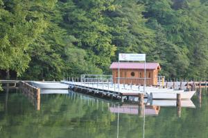 a dock with a small house and two boats on the water at Ferienwohnung Stechlin, Neuglobsow in Stechlin