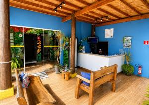 a room with two wooden benches and a counter at Beija Flor Pousada in Ubatuba