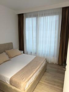 a bedroom with a bed and a large window at Lunea Apartment Palm Residence in Vlorë +7 photos