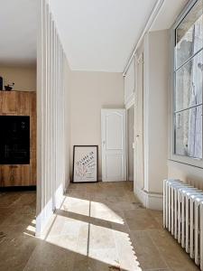 a hallway with white walls and a window at Maison Léon in Dole