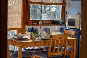 a dining room table with chairs and a table and a microwave at Apartman Jedro in Vukovar