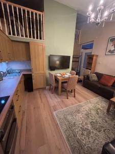 a kitchen and living room with a table and a couch at Hollybrake Haven Gatwick in Crawley