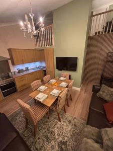 a living room with a wooden table and chairs at Hollybrake Haven Gatwick in Crawley
