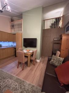a living room with a table and chairs and a television at Hollybrake Haven Gatwick in Crawley +24 photos
