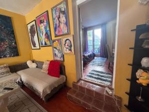 a living room with a couch and pictures on the wall at MM Apartman in Foča