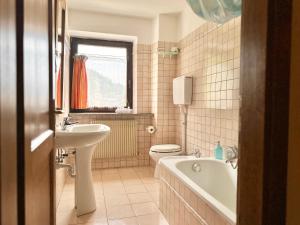 a bathroom with a sink and a tub and a toilet at Chalet Rustico Bertolini per Gruppi! in Vermiglio +93 photos
