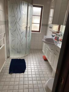 a bathroom with a shower and a blue towel on the floor at Sandbybäcksvägen 1 in Borrby +16 photos