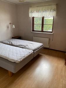 a bedroom with a bed and a window at Sandbybäcksvägen 1 in Borrby