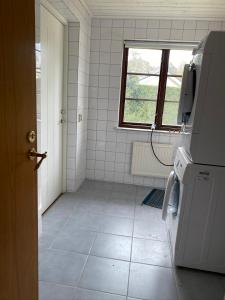 a bathroom with a tiled floor and a window at Sandbybäcksvägen 1 in Borrby