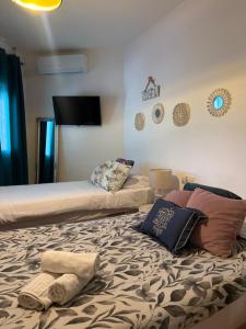 a bedroom with two beds with towels on the bed at Evens-Goretti House in Mairena del Aljarafe