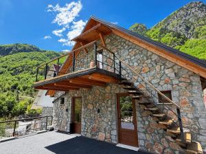a stone house with a staircase on the side of it at Vila Shkalla in Theth