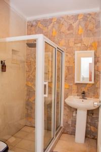 a bathroom with a shower and a sink at The Jam Lodge in Freetown +130 photos