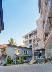 an apartment building with a palm tree in the background at The Jam Lodge in Freetown