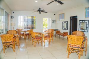 a dining room with tables and chairs and windows at The Jam Lodge in Freetown