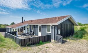 a small house with a picnic table on a deck at VE265-Vejers-Strand-Nordvej-98-A in Vejers Strand