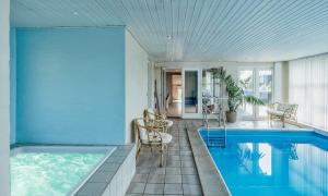 a house with a swimming pool with chairs and a table at VE265-Vejers-Strand-Nordvej-98-A in Vejers Strand